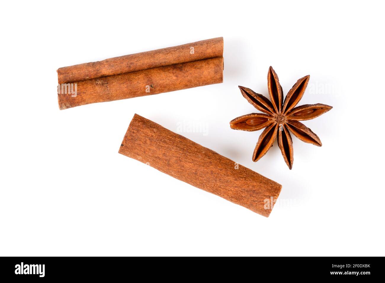 Zimtstangen und Anis-Sternwürze. Nahaufnahme-Makro auf weißem Hintergrund mit hellem Schatten isoliert. Draufsicht, flach liegend, Stockfoto