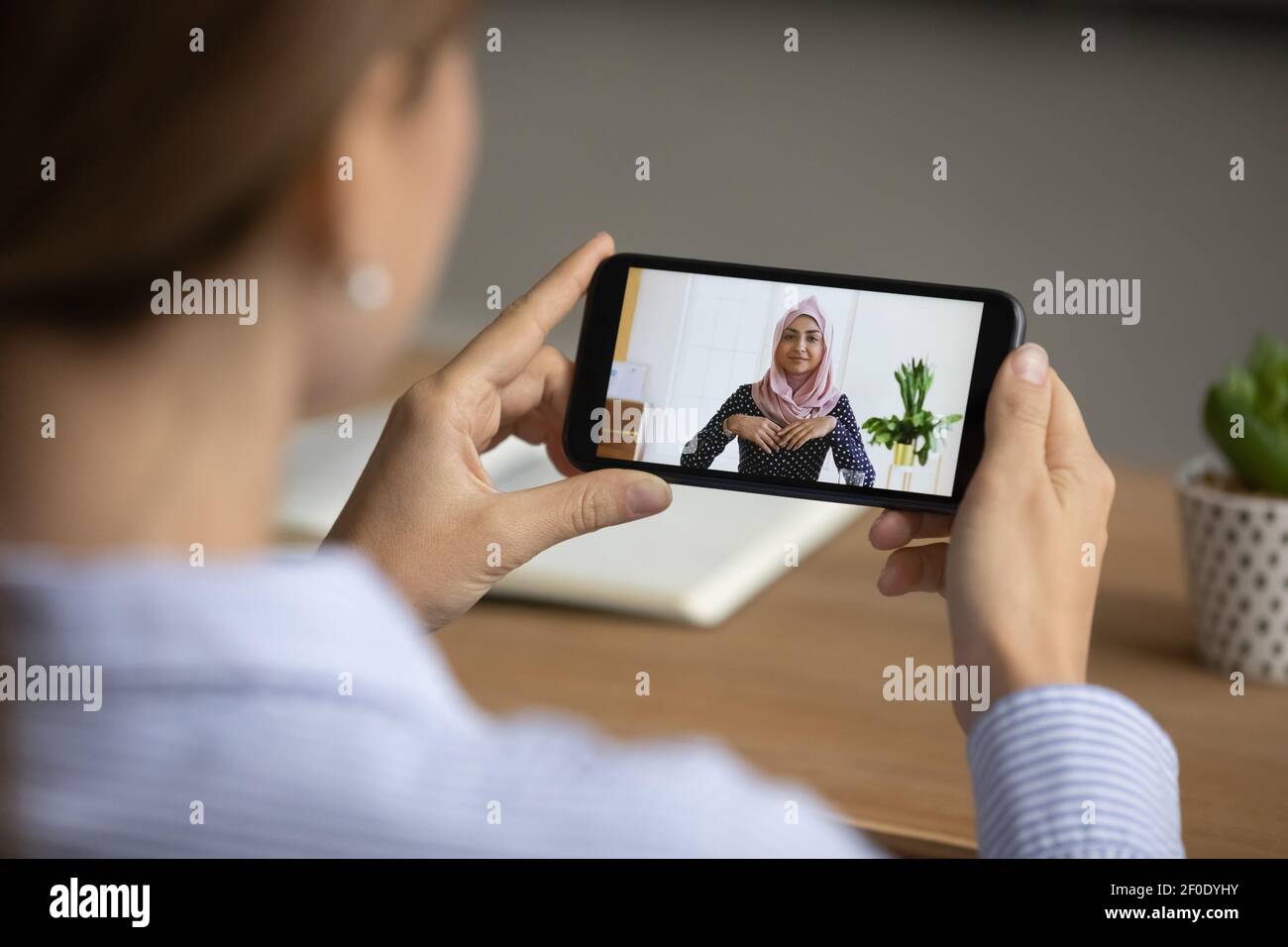 Weibliche multiethnische Kollegen sprechen in einem Videoanruf auf der Zelle Stockfoto