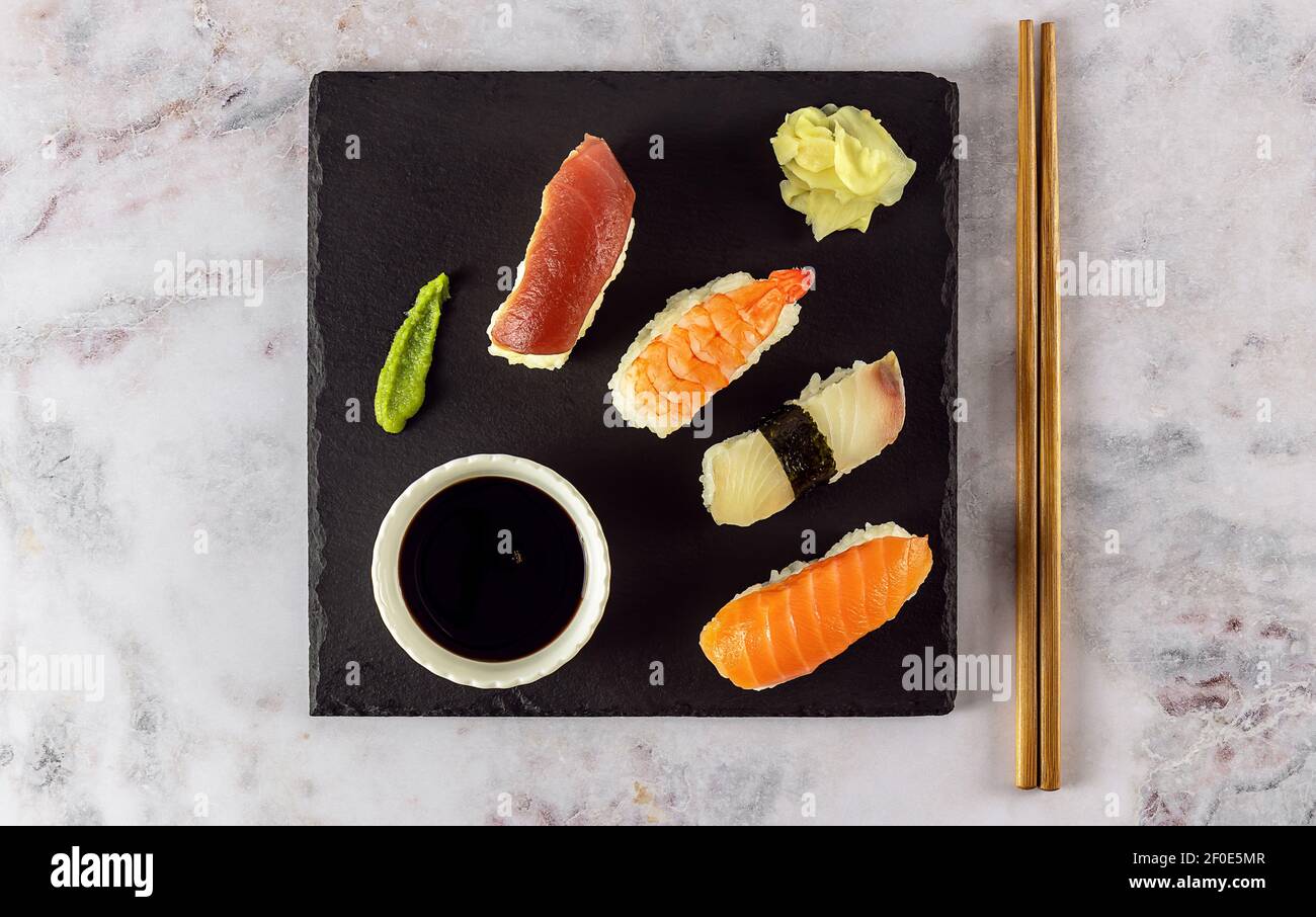 Japanisches Sushi-Essen. Nigiri mit Thunfisch, Lachs, Garnelen serviert mit Sojasauce, Ingwer und Wasabi. Stockfoto