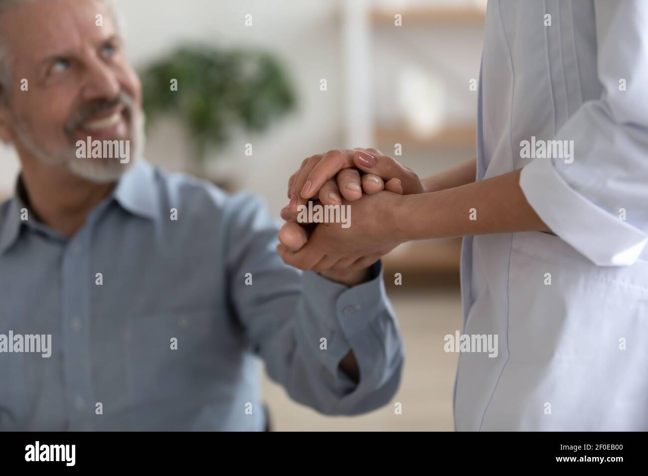 Unterstützende Krankenschwester tröstet älteren männlichen Patienten Stockfoto