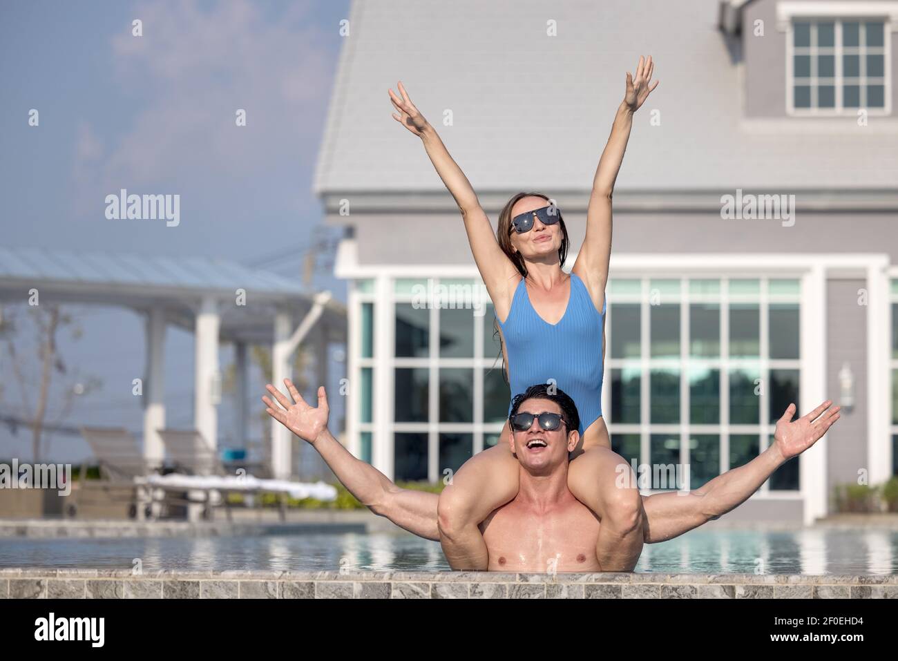 Fröhliches Paar Schwimmen in einem Pool im Urlaub Zeit genießt Stockfoto