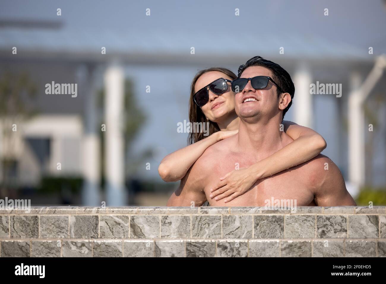 Fröhliches Paar Schwimmen in einem Pool im Urlaub Zeit genießt Stockfoto