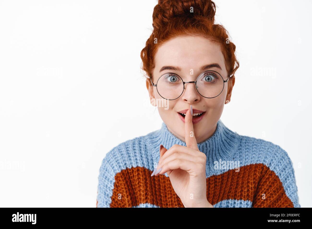 Nahaufnahme Porträt von aufgeregt Mädchen in Brille erzählt Geheimnis, shhh  shush Geste mit Finger auf die Lippen gedrückt, lächeln und Klatsch, fragen  Stockfotografie - Alamy