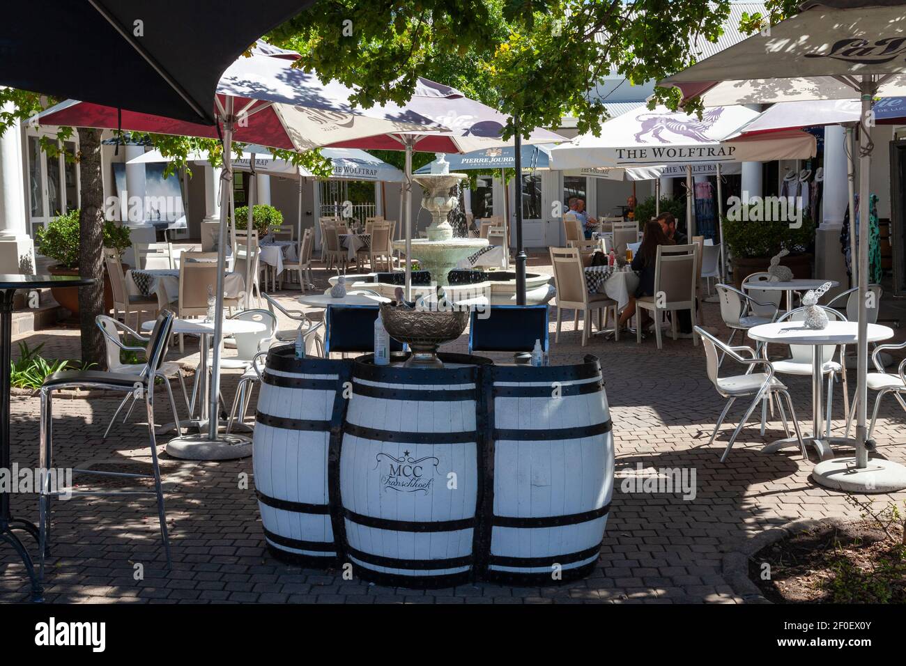 Dorfplatz mit Tischen im Freien des MCC Restaurant, Franschhoek, Western Cape Winelands, Western Cape, Südafrika mit Weinfass Dekor Stockfoto