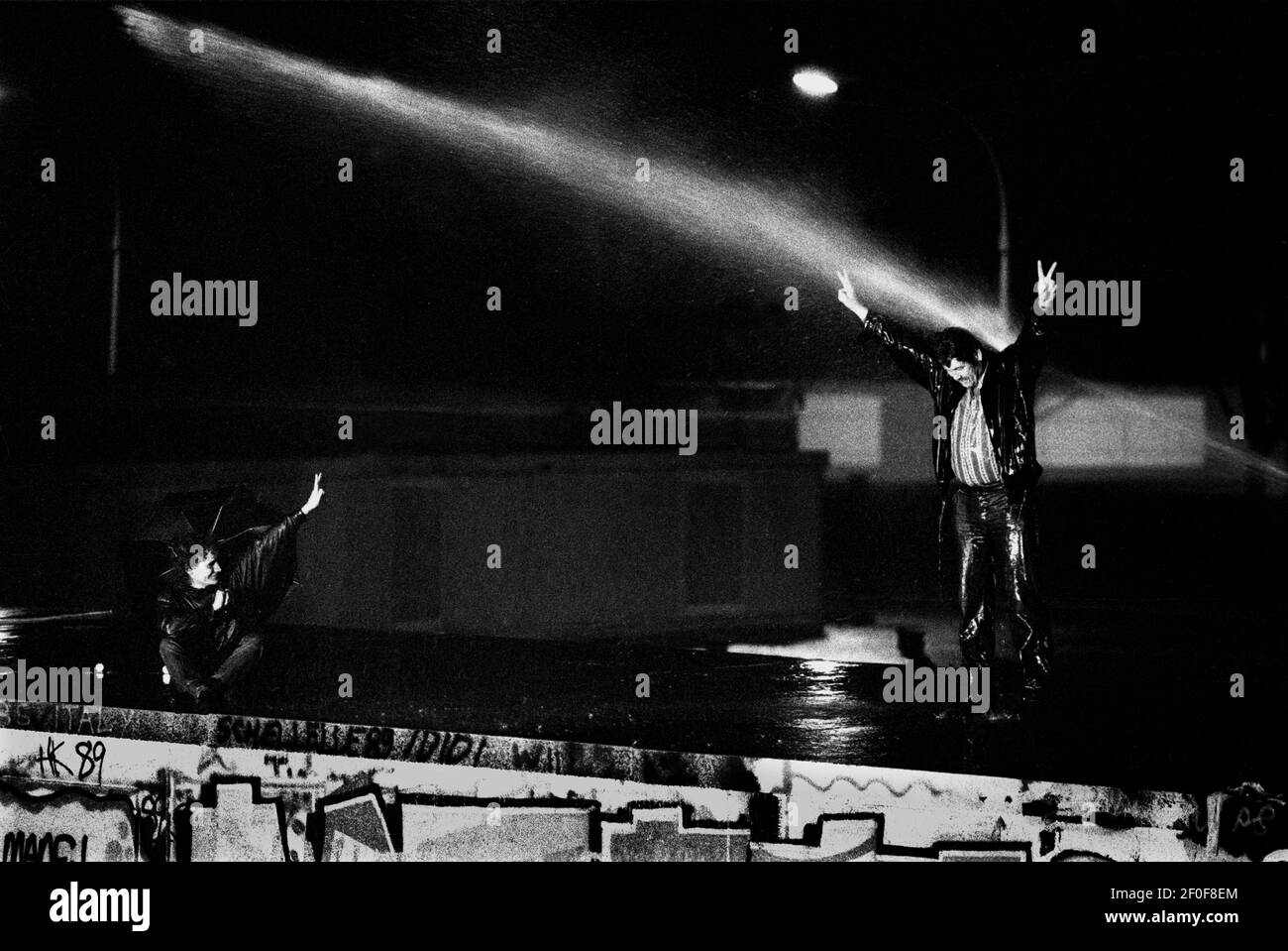 Berlin 9. November 1989. In der Nacht, als die Mauer fiel. Tausende Westberliner kletterten und saßen an der Mauer am Brandenburger Tor, als DDR-Grenzposten versuchten, die Menschen von der Mauer zu schlauchen.COPYRIGHT PHOTO BY BRIAN HARRIS 07808-579804 Stockfoto