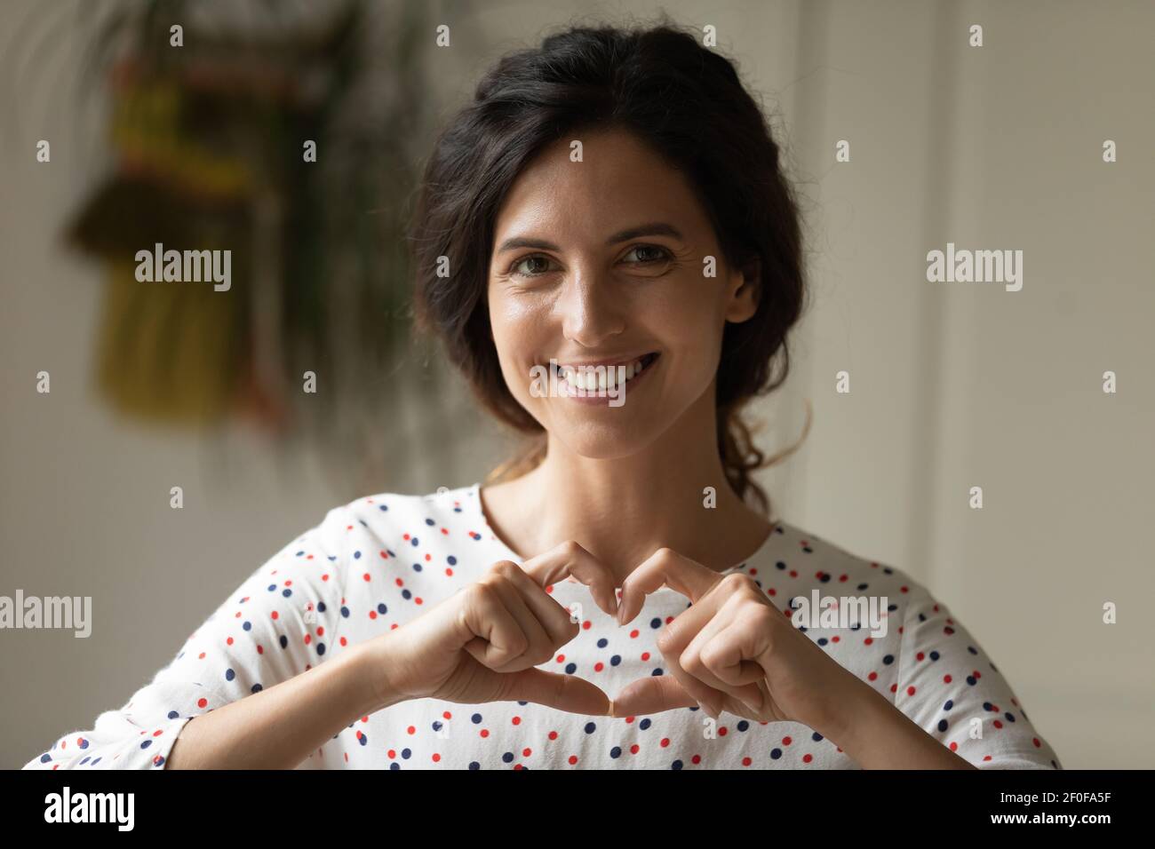 Lächelnde Frau Freiwillige zeigen Finger Herz lenken die Aufmerksamkeit auf Nächstenliebe Stockfoto