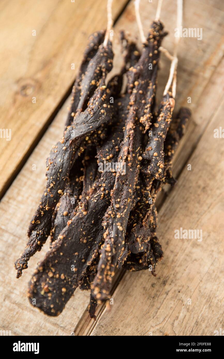 Biltong aus Damwild-Wildbret, das an Schnüren aufgehängt, luftgetrocknet und mit Salz, Essig und Zucker und verschiedenen Gewürzen einschließlich cr ausgehärtet wurde Stockfoto