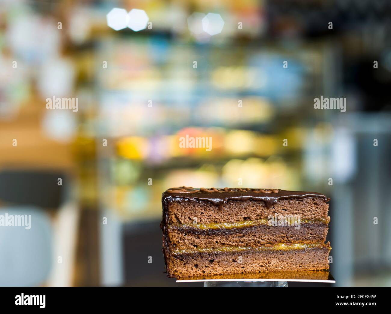 Ein Stück Schokolade-Marmelade geschichteten Kuchen, mit Bokeh Hintergrund Stockfoto