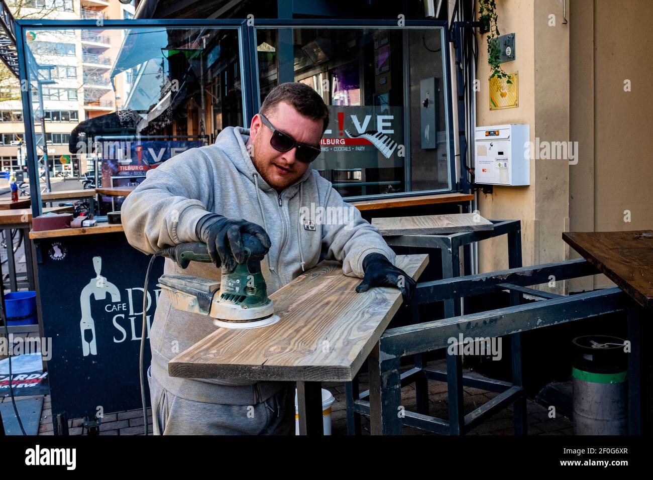 Tilburg, Niederlande. Seit das Corona Virus in das Land gekommen war, um Infektionen und Covid 19 zu verursachen, hatte es innerhalb von Wochen einen großen Einfluss auf das öffentliche Leben. Cafe & Restaurant Besitzer sind gerade dabei, ihre Einrichtung zu renovieren und zu reinigen. Stockfoto
