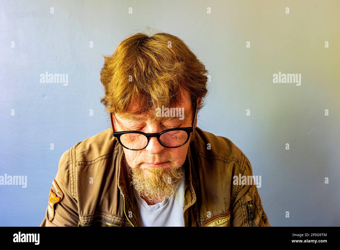 Tilburg, Niederlande. Portrait von Guido Koppes, einem reifen erwachsenen Mann mit einem Corona Style Hairdue, trägt eine Brille. Studio Porträt. Stockfoto