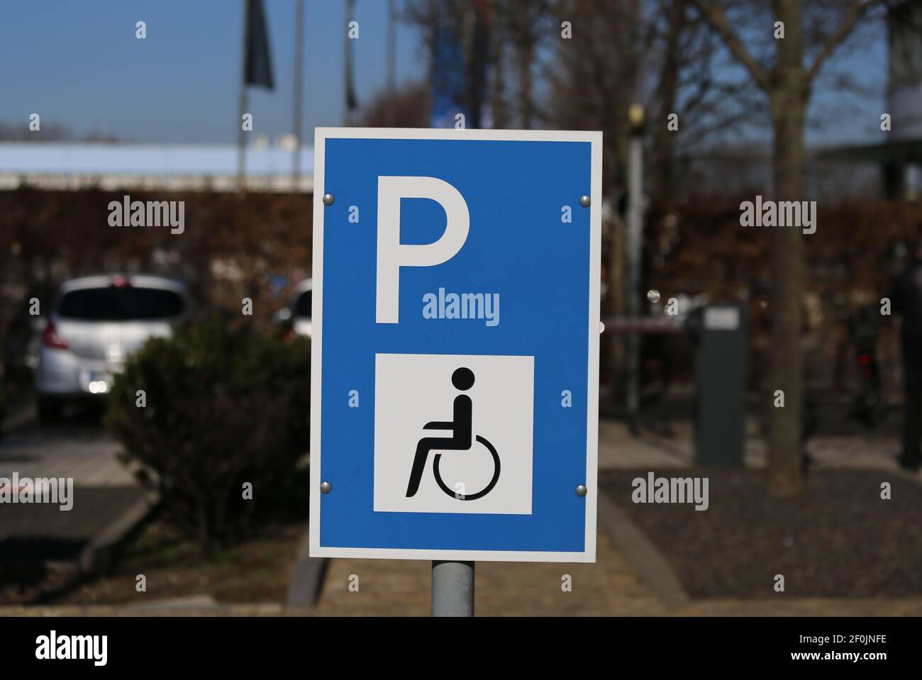 Nahaufnahme von isolierten blau weiß für behinderte Menschen Parkplatz Schild reserviert, verschwommener Hintergrund Stockfoto