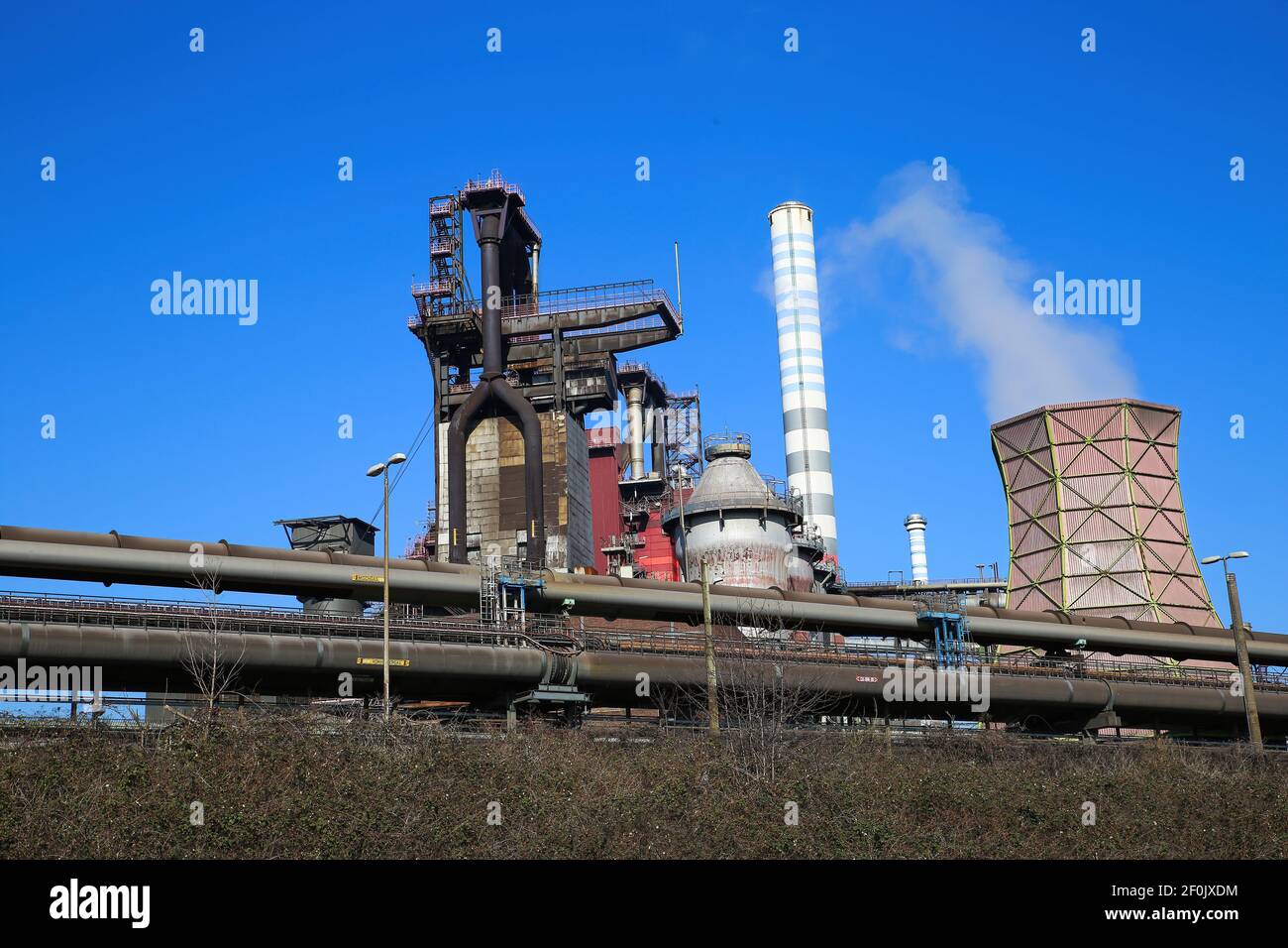 Duisburg (ruhrgebiet), Deutschland - März 1. 2021: Blick auf Industriekomplex mit rauchenden Schornsteinen und Turm gegen blauen Himmel - Thyssen Krupp Steel comp Stockfoto
