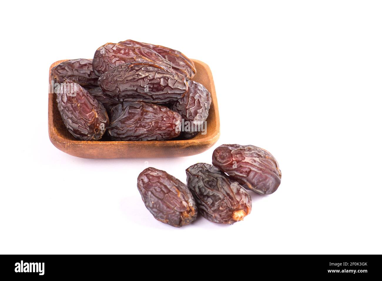 HURMA, Termine. Getrocknete Datteln Obst mit Holzplatte auf weißem Hintergrund. Beliebte Frucht des Ramadan. Stockfoto
