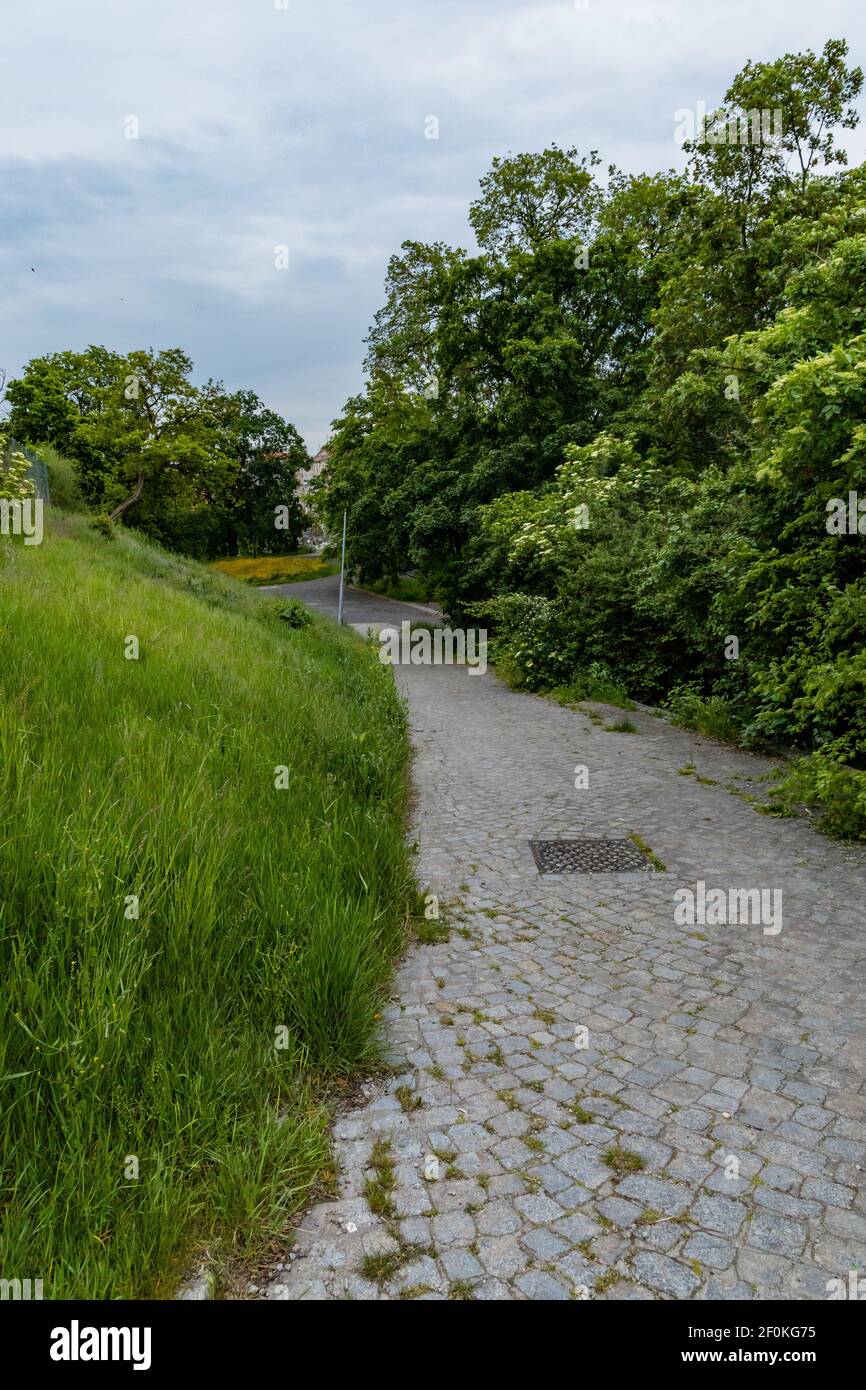 Langer Ziegelweg zum Abhang des kleinen Hügels bei Bewölkung Tag Stockfoto