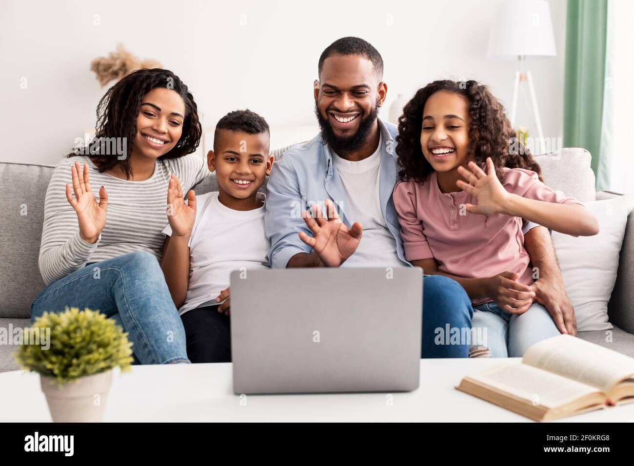 Schwarze Familie mit Videocall mit Laptop winkende Hände Stockfoto