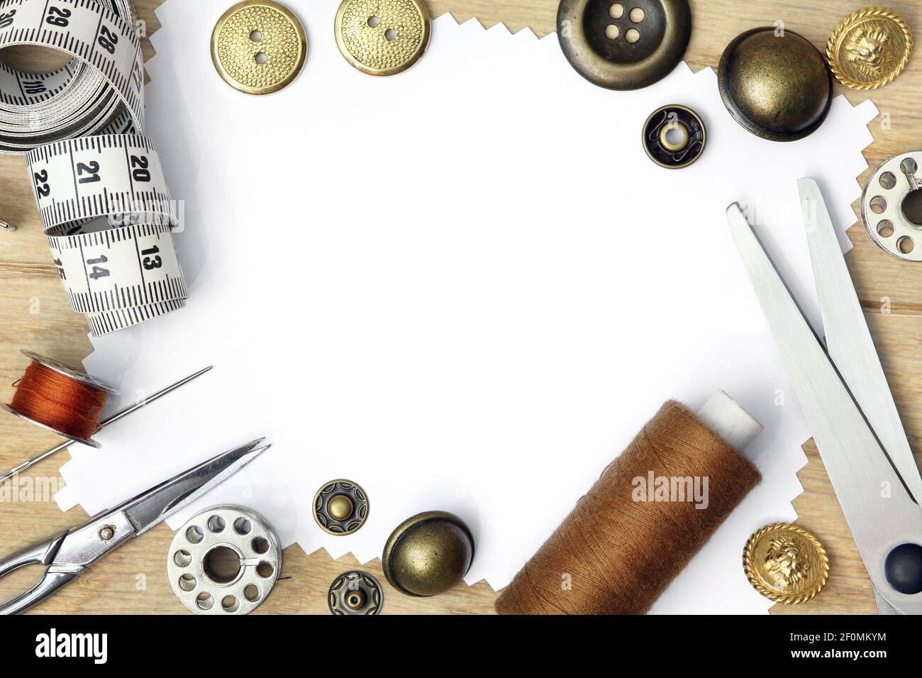 Braune Sepia-Schablone für Nähprodukt mit weißem Hintergrund und Satz von Schneidewerkzeugen, Schere, Maßband, Knopf und Spule von Fäden Stockfoto