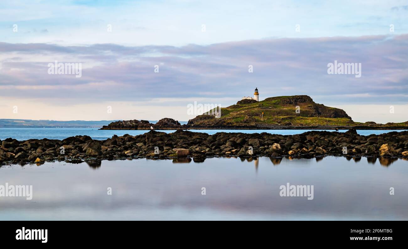 Fidra Island und Leuchtturm am Horizont mit felsigen Ufer und Gezeitenbecken Wolke Reflexionen, Yellowcraig, East Lothian, Schottland, Großbritannien Stockfoto