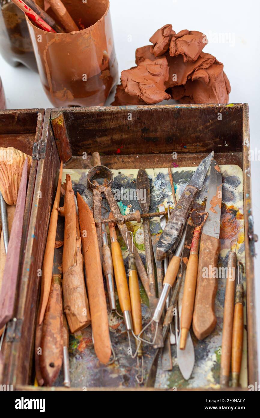 Kunstkonzept. Instrumente zur Modellierung von Skulpturen. Box mit verschiedenen Werkzeugen und Objekten, die verwendet werden, um Skulpturen mit Tonresten modellieren. Stockfoto