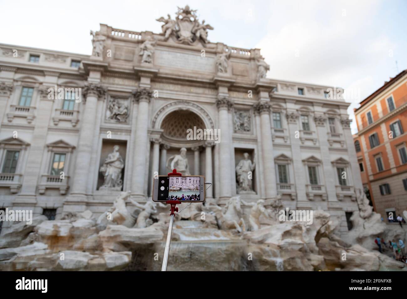 Smartphone auf einem Stick fotografiert Fontana di trevi in Rom, Italien. Selektiver Fokus. Stockfoto