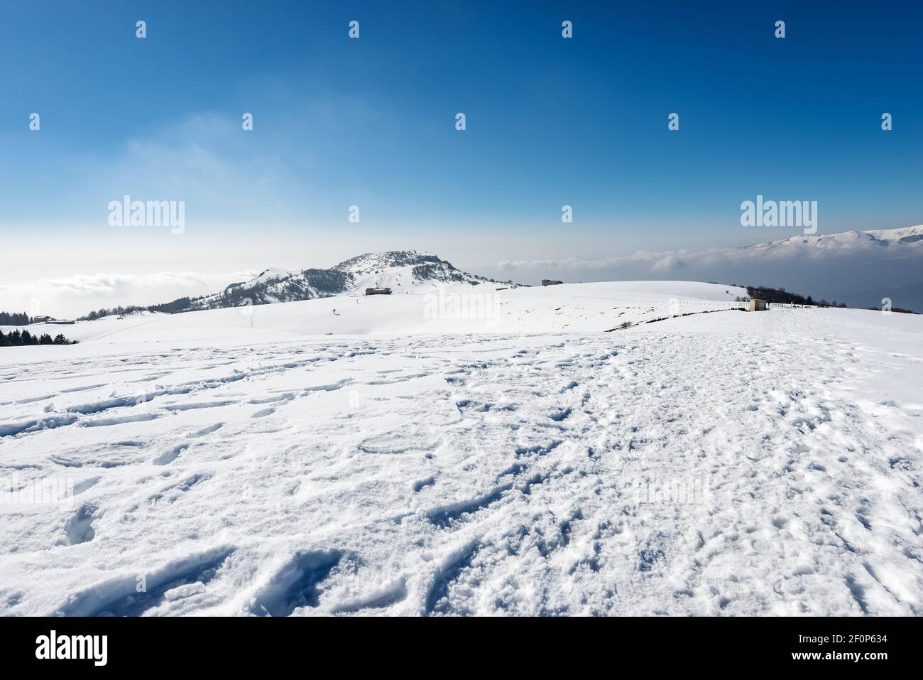 Berggipfel von Corno d'Aquilio im Winter mit Schnee. Lessinia Plateau, Regionaler Naturpark. Monte Baldo auf der rechten Seite. Venetien, Italien, Europa. Stockfoto