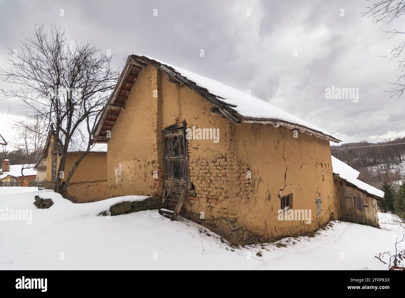 Traditionelle Balkan-Architektur, ländliches Haus aus Ton und Holz. Winterlandschaft. Stockfoto