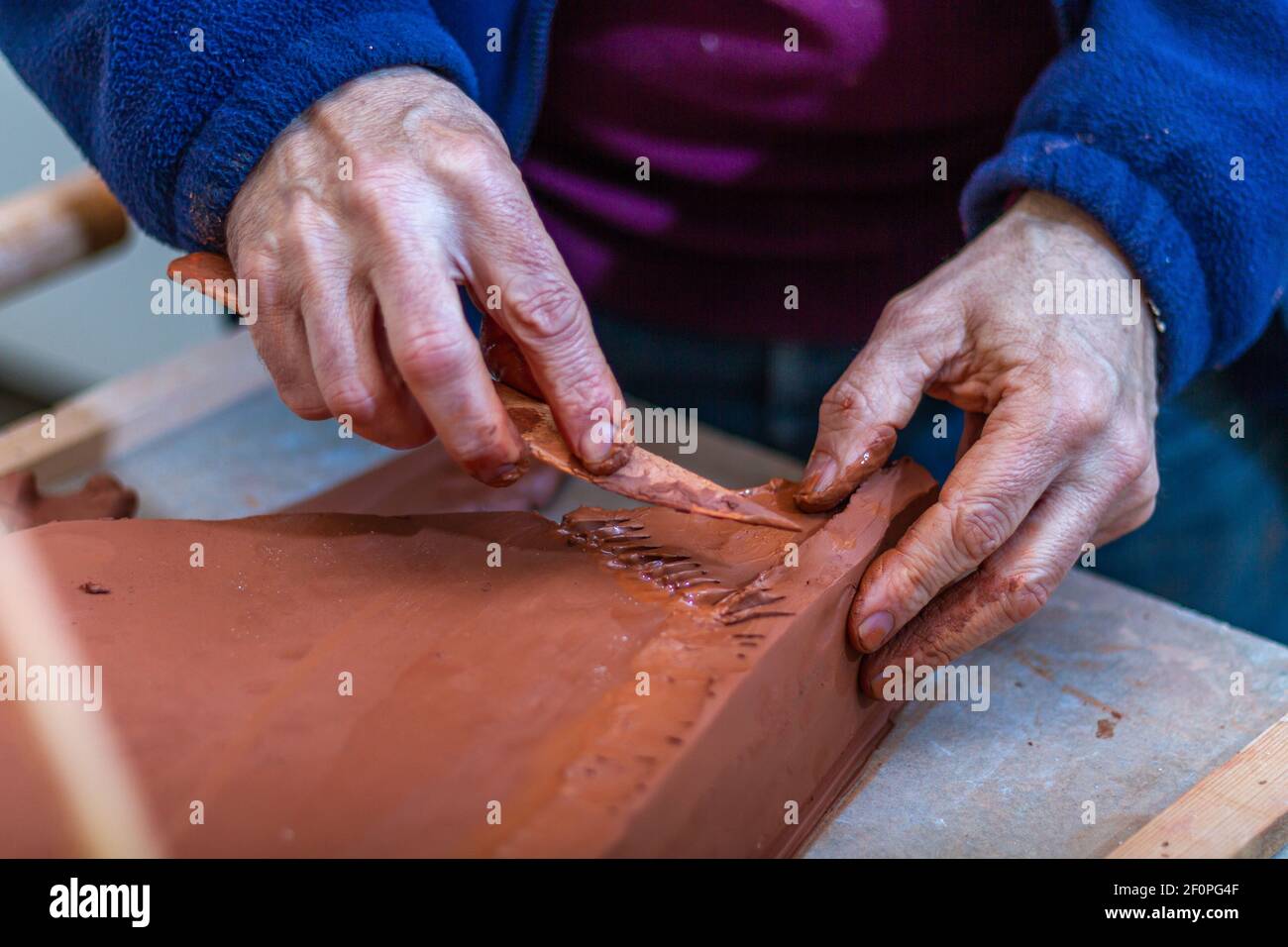 Kunstkonzept. Der Bildhauer modelliert in seinem Architekturstudio die Basis einer Skulptur mit Ton. Stockfoto