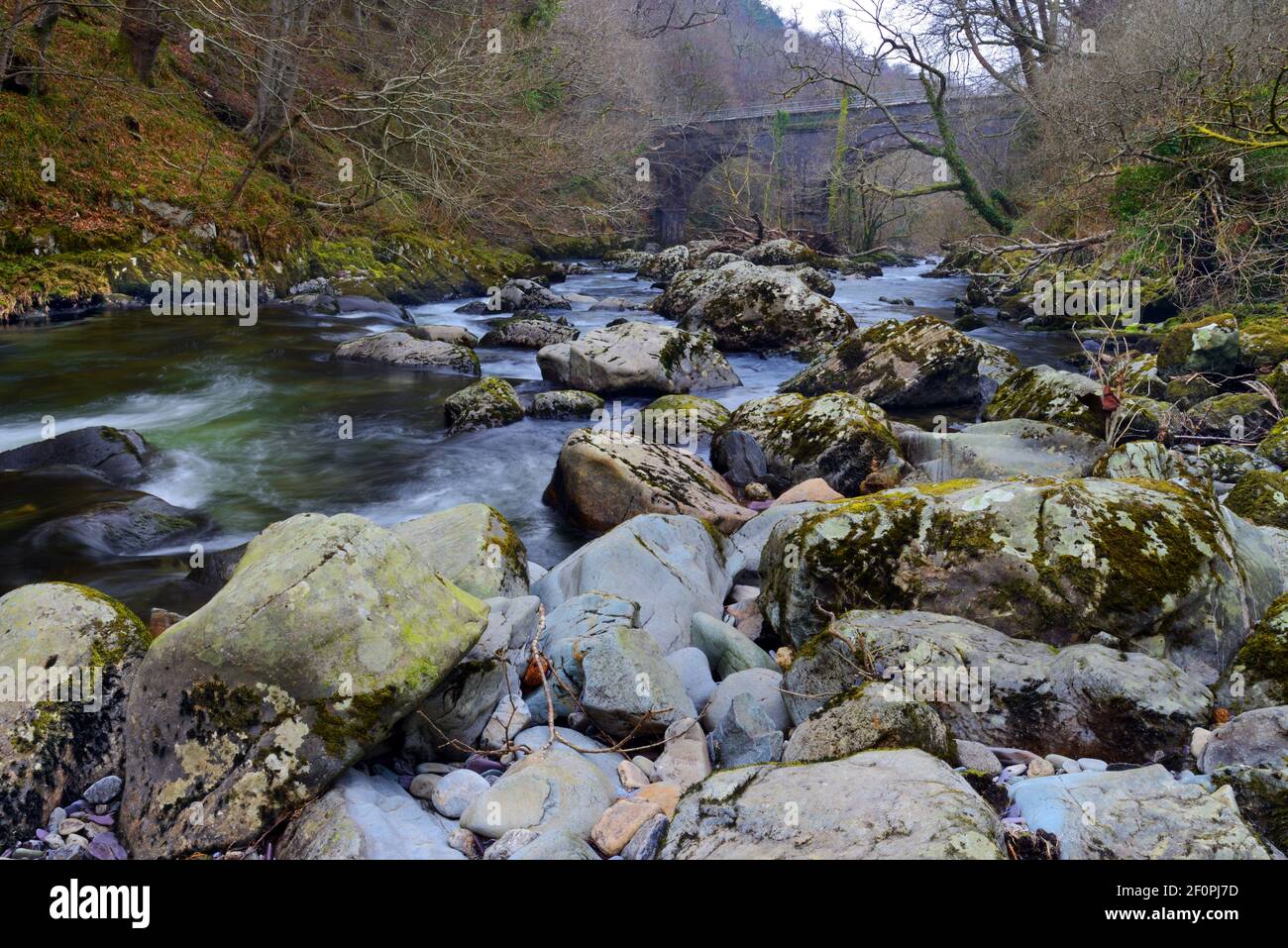 Der Ogwen-Fluss entspringt im Ogwen-See in Snowdonia, ist aber hier in seinem unteren Bereich nahe dem alten Eisenbahnviadukt bei Tregarth zu sehen. Stockfoto Der Ogwen-Fluss entspringt im Ogwen-See in Snowdonia, ist aber hier in seinem unteren Bereich nahe dem alten Eisenbahnviadukt bei Tregarth zu sehen. Stockfoto