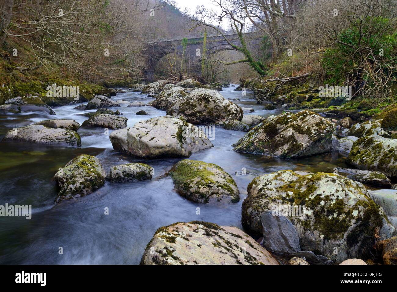Der Ogwen-Fluss entspringt im Ogwen-See in Snowdonia, ist aber hier in seinem unteren Bereich nahe dem alten Eisenbahnviadukt bei Tregarth zu sehen. Stockfoto Der Ogwen-Fluss entspringt im Ogwen-See in Snowdonia, ist aber hier in seinem unteren Bereich nahe dem alten Eisenbahnviadukt bei Tregarth zu sehen. Stockfoto