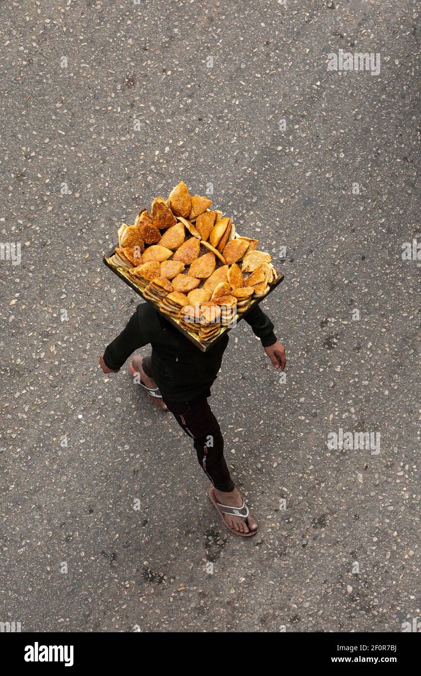 Luftaufnahme einer Person, die die Straße mit einem Tablett von Gebäck auf dem Kopf ausgeglichen, Talaat Harb Street, Downtown Kairo, Ägypten Stockfoto