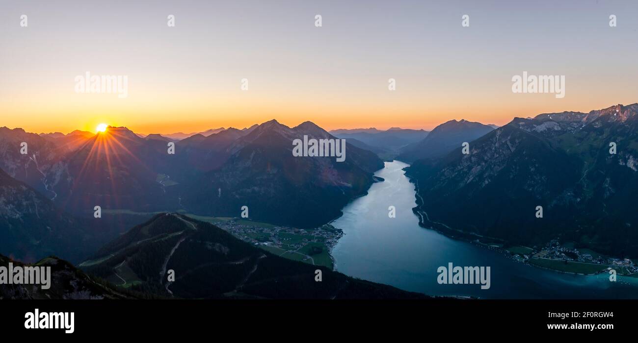 Letzte Sonnenstrahlen über der Berglandschaft bei Sonnenuntergang, Blick vom Gipfel des Baerenkopf auf den Achensee und die Gipfel Seebergspitze und Seekarspitze, Panorama Stockfoto