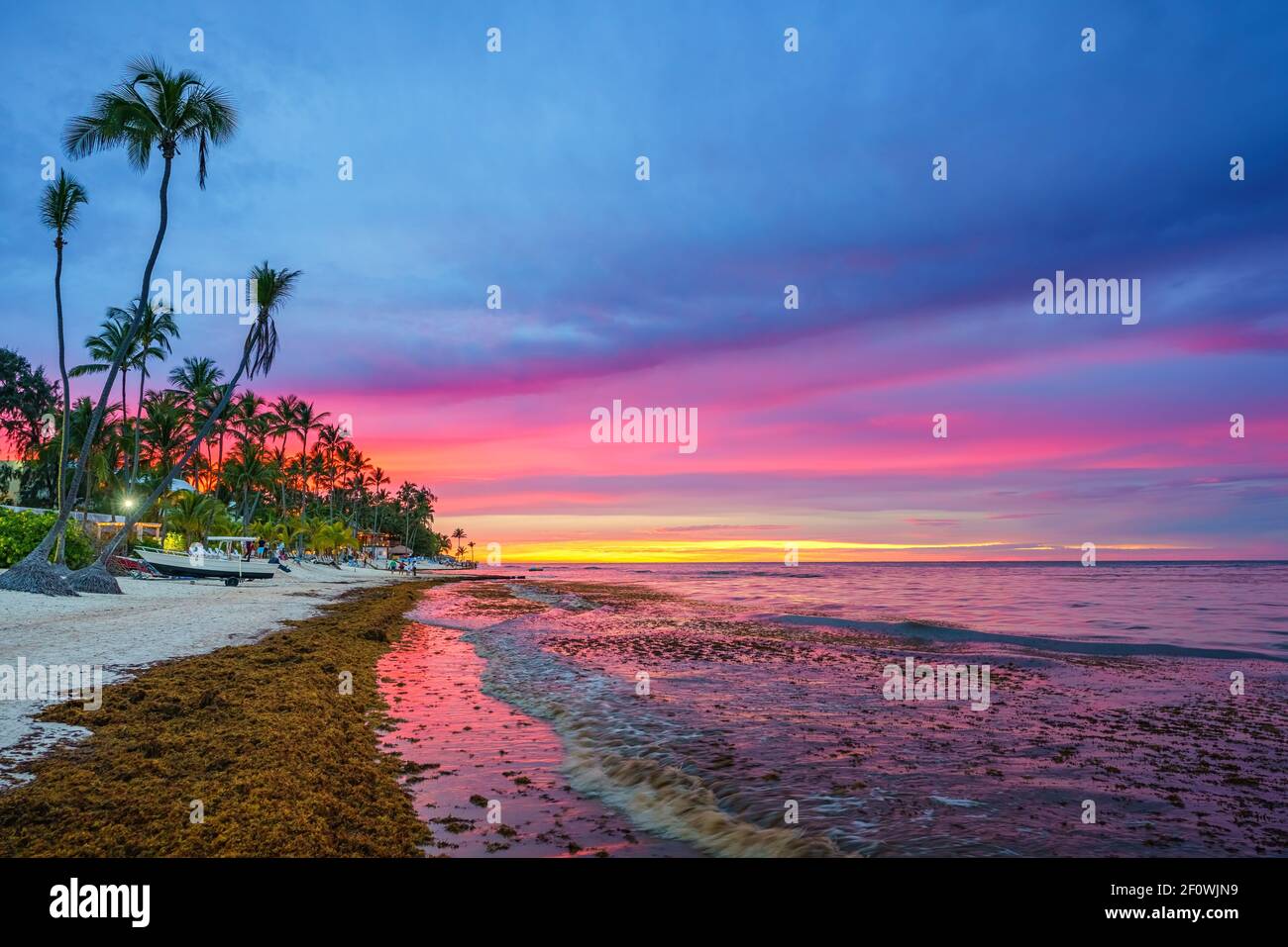Lebhafter Sonnenuntergang über dem tropischen Strand und Palmen in der Dominikanischen republik Stockfoto