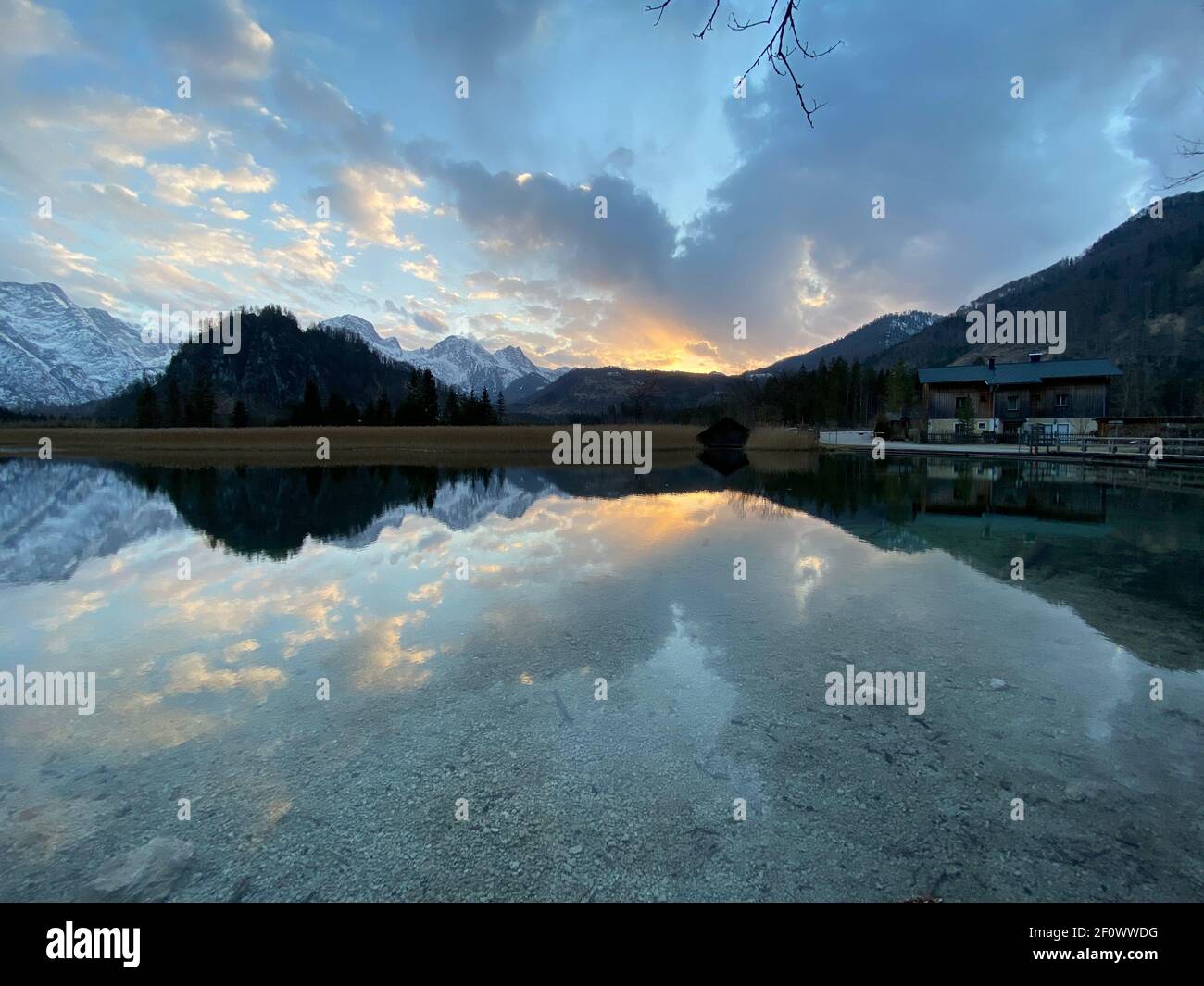 Spiegelungen eines Sonnenuntergangs über dem alpinen Bergsee Almsee in Österreich Stockfoto