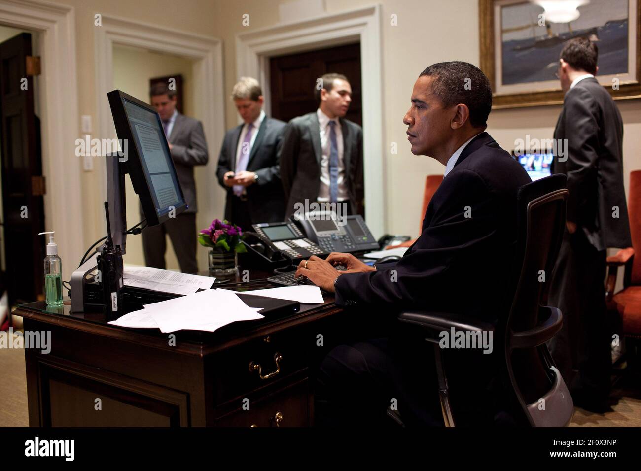 Präsident Barack Obama arbeitet an seiner Erklärung im Outer Oval Office, 2. August 2011. Im Hintergrund stehen von links Dan Pfeiffer, Jay Carney, Jon Lovett und Senior Advisor David Plouffe Stockfoto