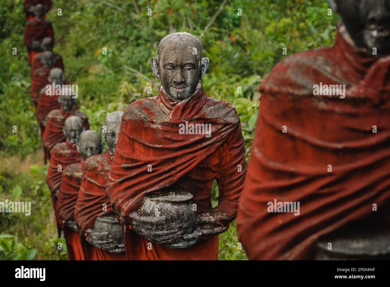 Hunderte von alten Statuen buddhistischer Mönche, die Almosen sammeln, umgeben den Win sein Taw Ya Buddha in Mawlamyine, Myanmar (Burma). Stockfoto