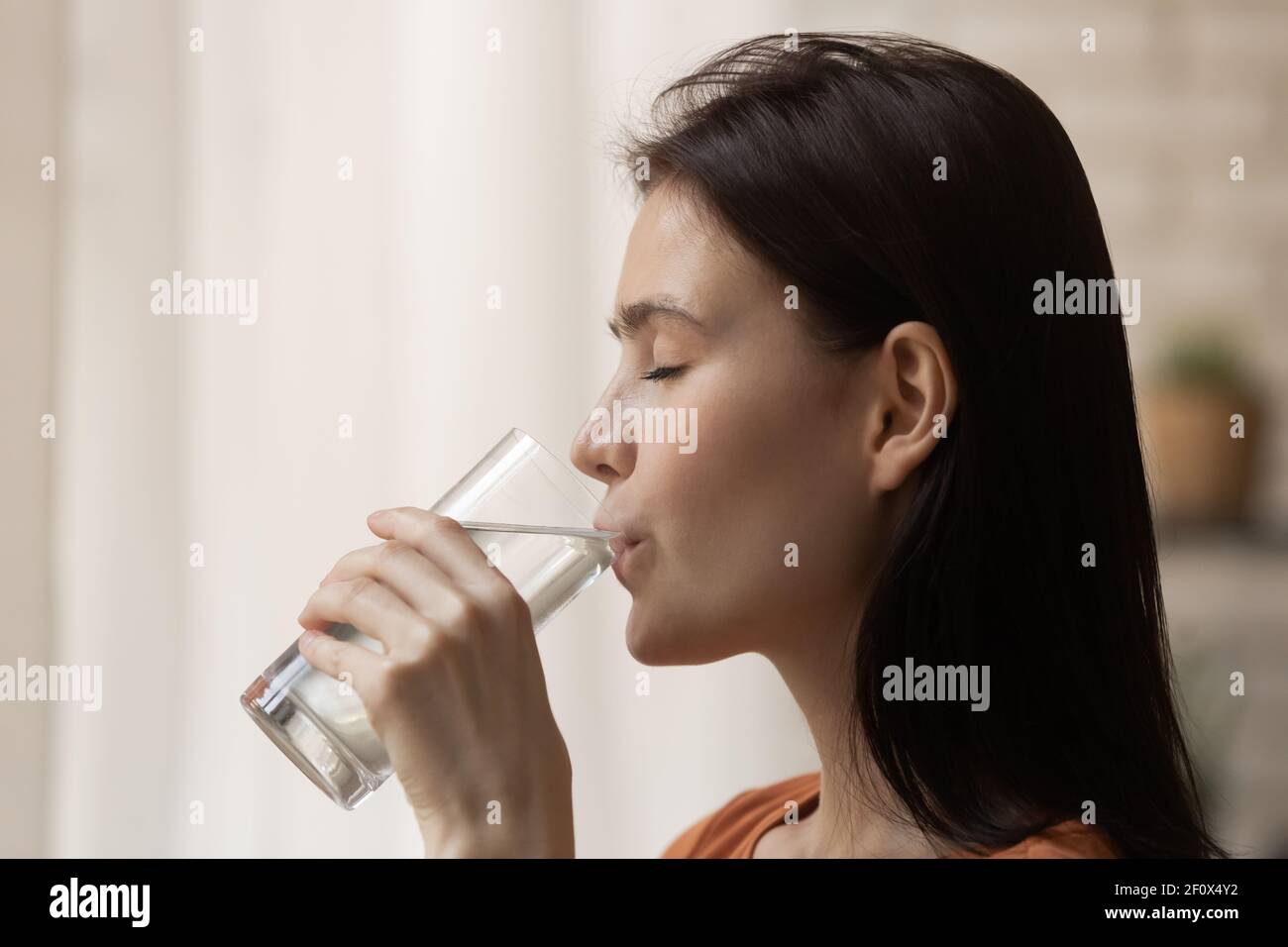 Durstige Teenager weibliche Stand mit geschlossenen Augen genießen Trinkwasser Stockfoto