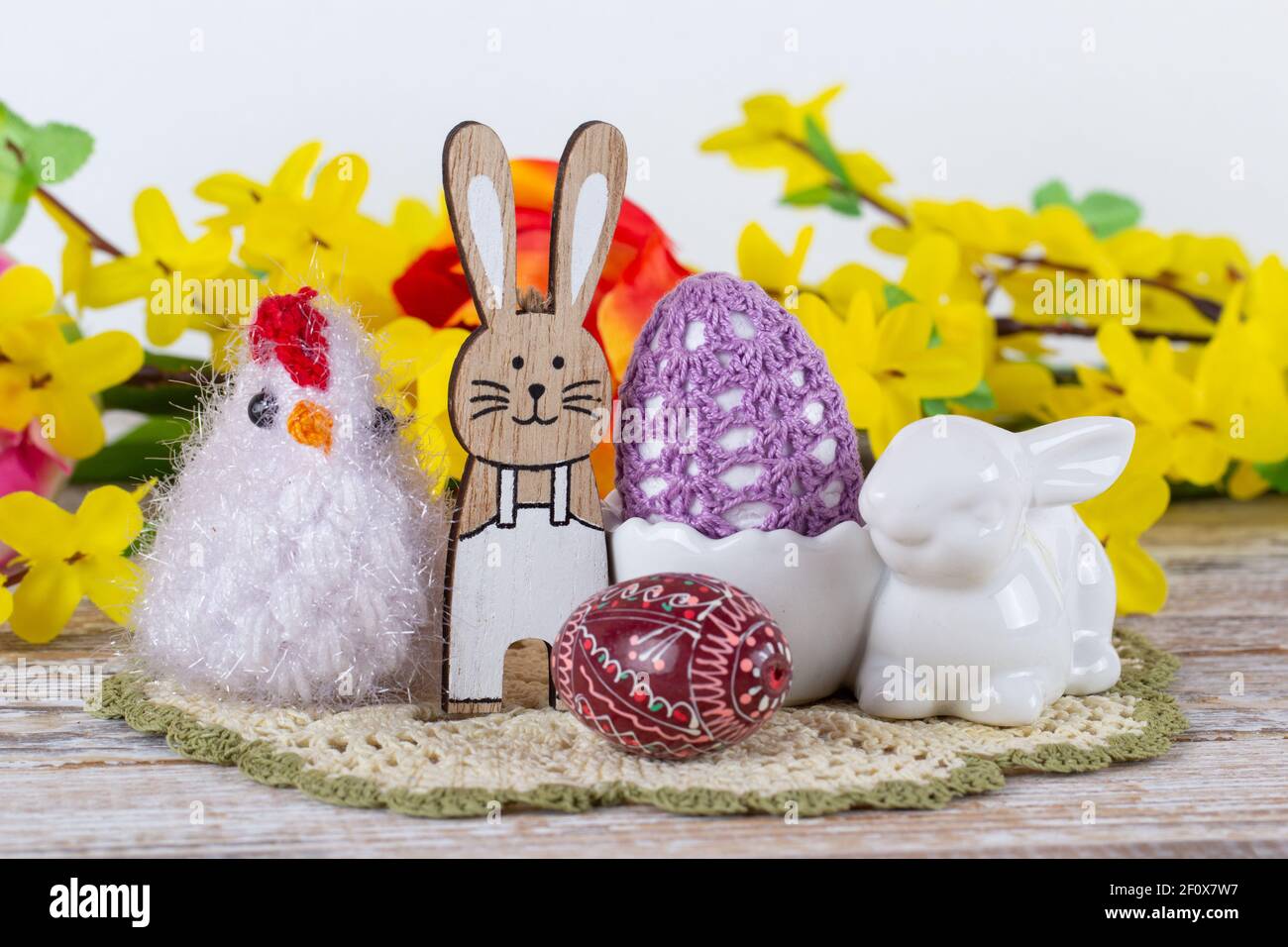 Osterhase, Huhn, Ostereier mit Frühlingsblumen auf einem Holztisch. Stockfoto