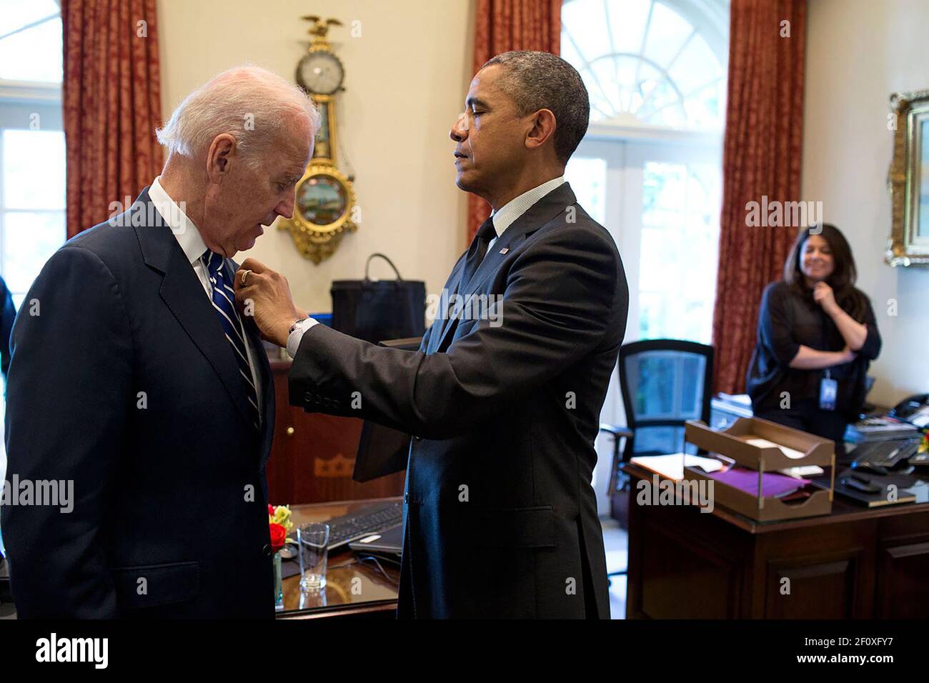 Präsident Barack Obama passt eine Anstecknadel für Vizepräsident Joe Biden im Outer Oval Office an, 23. Mai 2014. Ferial Govashiri, persönlicher Assistent des Präsidenten steht auf der rechten Seite Stockfoto