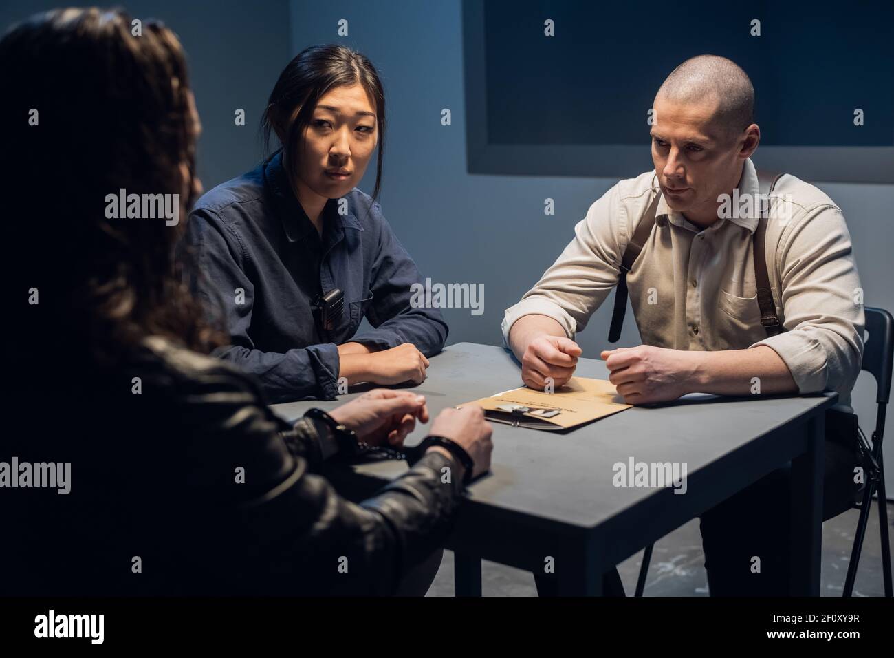 Der Ermittler führt ein Verhör durch, zeigt die verdächtigen Fotos von Komplizen Stockfoto