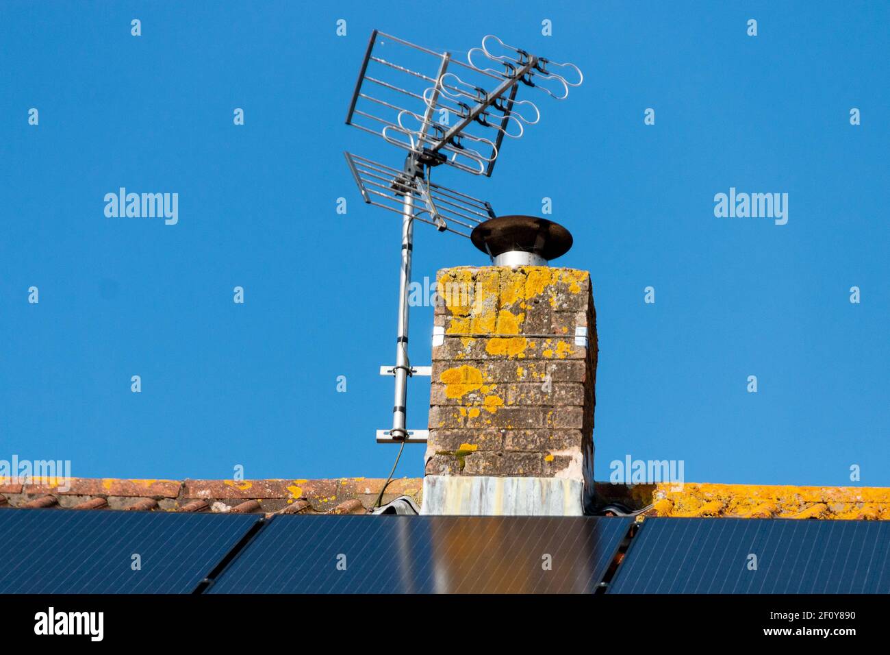 Nahaufnahme eines Schornsteins auf einem Wohngebiet Dach mit Sonnenkollektoren Stockfoto