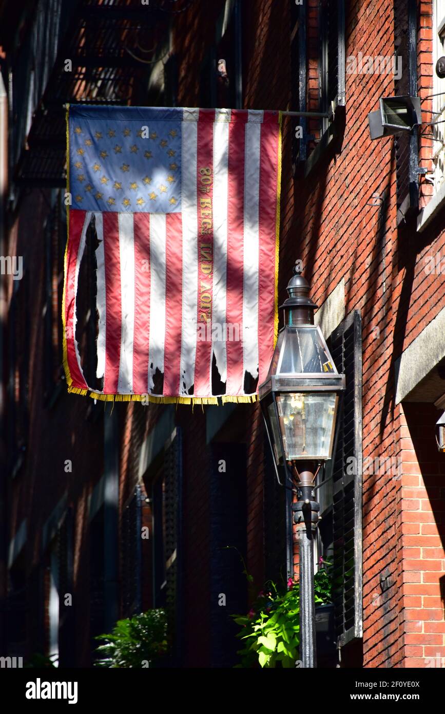 Betsy Ross Flagge hängt über den kolonialen Hausfronten entlang Acorn St. in Boston mit Backstein und Streelight-Features. Stockfoto