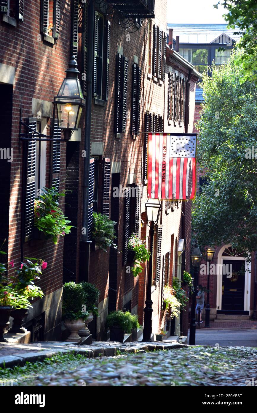 Betsy Ross Flagge hängt über den kolonialen Hausfronten entlang Acorn St. in Boston mit Backstein und Streelight-Features. Stockfoto