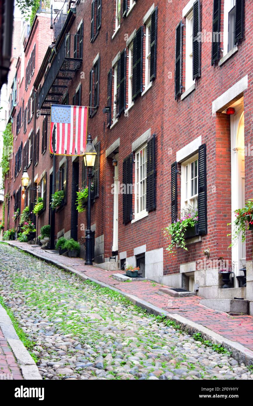 Betsy Ross Flagge hängt über den kolonialen Hausfronten entlang Acorn St. in Boston mit Ziegel und Streelight-Features. Bei Morgendämmerung. Stockfoto