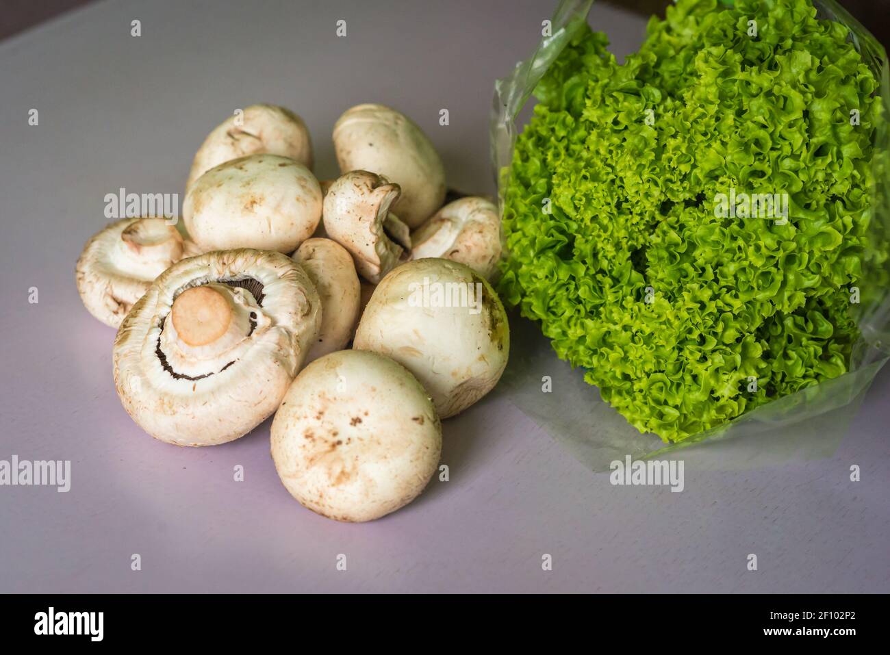 Pilze und Salat auf dem Tisch Stockfoto