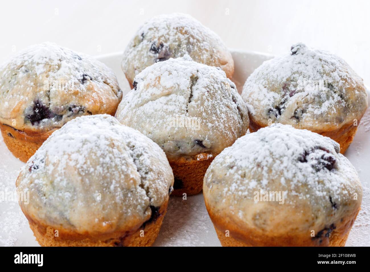 Hausgemachte, frisch gebackene Muffins mit Beeren auf dem Teller. Stockfoto