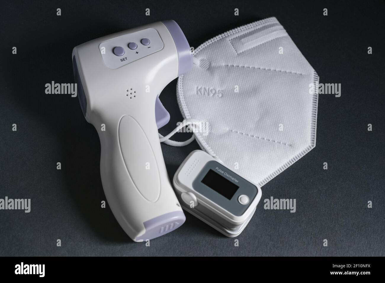 Pulsoximeter, digitales Fieberthermometer und FFP2 schützende Gesichtsmaske, covid19 Pandemie Krankheit, medizinische Werkzeuge Behandlung zu Hause Stockfoto
