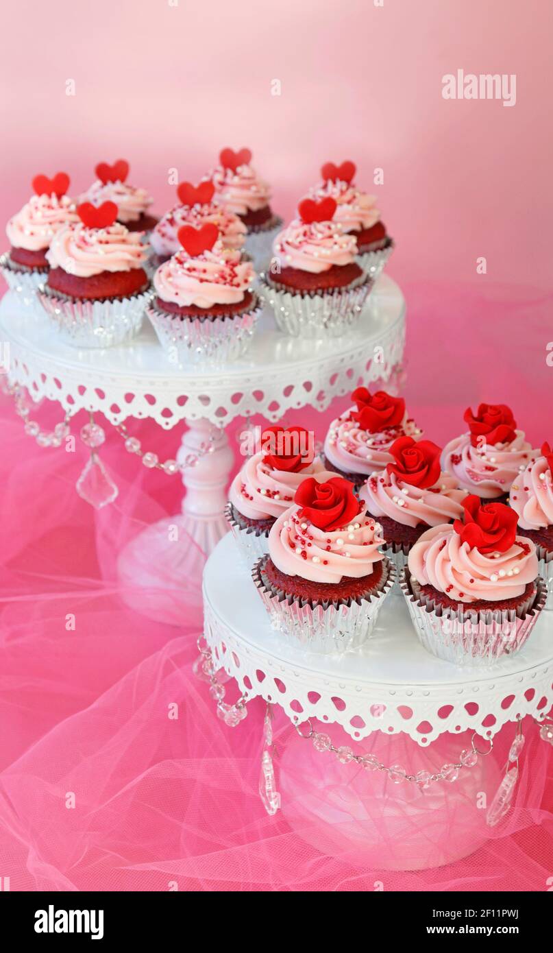 Cupcakes mit roten Rosen und Herzen für Valentinstag oder dekoriert Hochzeiten Stockfoto