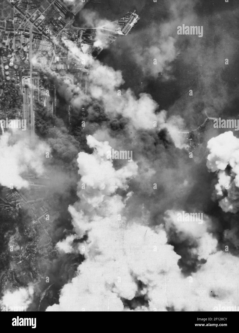 Schwarze und weiße Rauchsäulen aus dem Empire Dock, Singapur, Malaiische Halbinsel, nach einem Angriff von B-29 Superfestungen Stockfoto