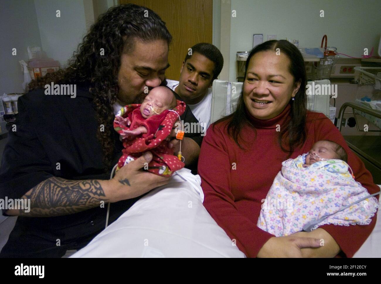 Pro-Wrestler Sam Fatu, links, küsst seinen kleinen Jungen, Marley, als seine Frau, Theresa Fuavai-Fatu, rechts, Hält ihre kleine Tochter Miracle, während der Sohn Journey Fatu, 12, schaut seinem Vater am 22. Dezember 2008 im Mercy San Juan in Sacramento, Kalifornien, über die Schulter. Ärzte mussten einen Notfall Kaiserschnitt durchführen, nachdem Mama einen Herzstillstand erlitten hatte. Während der Geburt wurde sie wiederbelebt. (Foto von Lezlie Sterling/Sacramento Bee/MCT/Sipa USA) Stockfoto