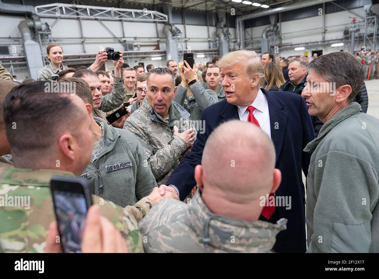Präsident Donald Trump schüttelt sich die Hände und fotografiert mit Militärs während eines Zwischenstopps auf dem Luftwaffenstützpunkt Ramstein in Deutschland am Mittwochabend, dem 26 2018. Dezember, nach seinem unangekündigten Besuch bei US-Truppen auf dem Luftwaffenstützpunkt Al-Asad im Irak. Stockfoto