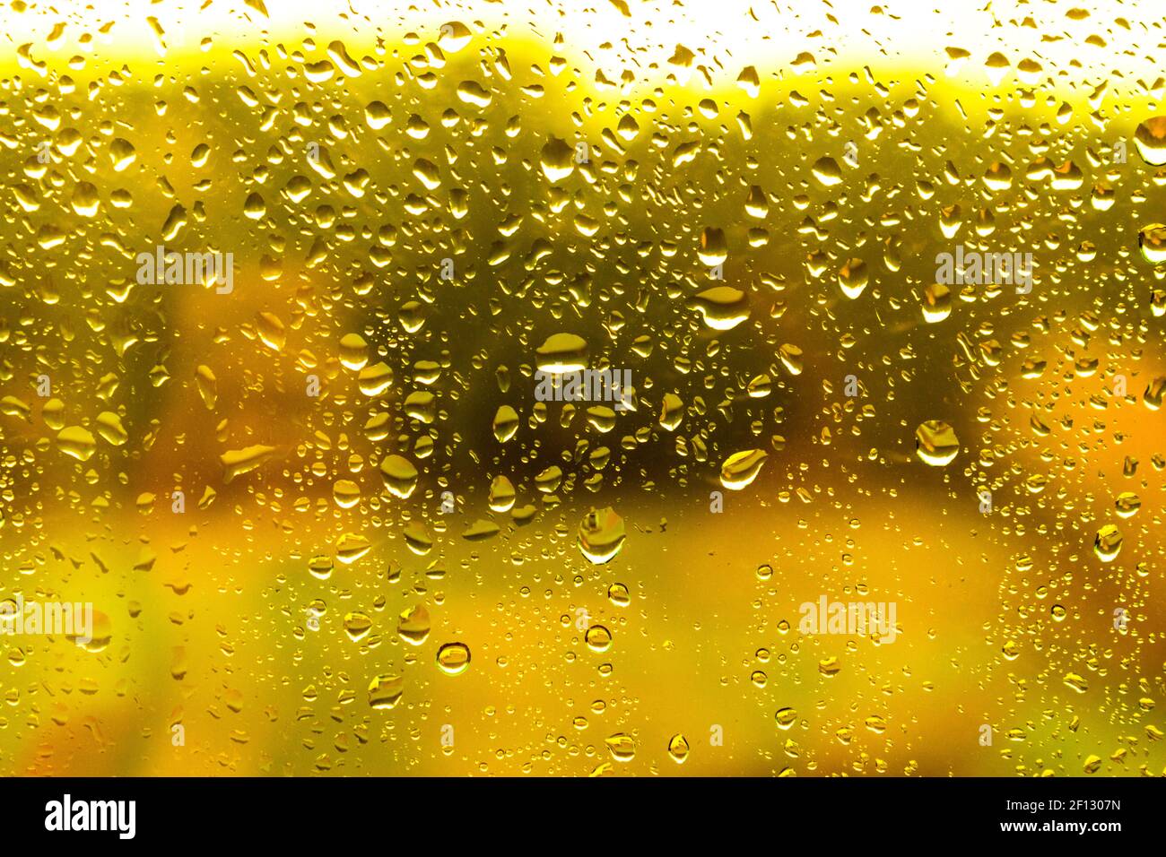 Tropfen Wasser auf das Glas mit gelbem Hintergrund Regentag Stockfoto